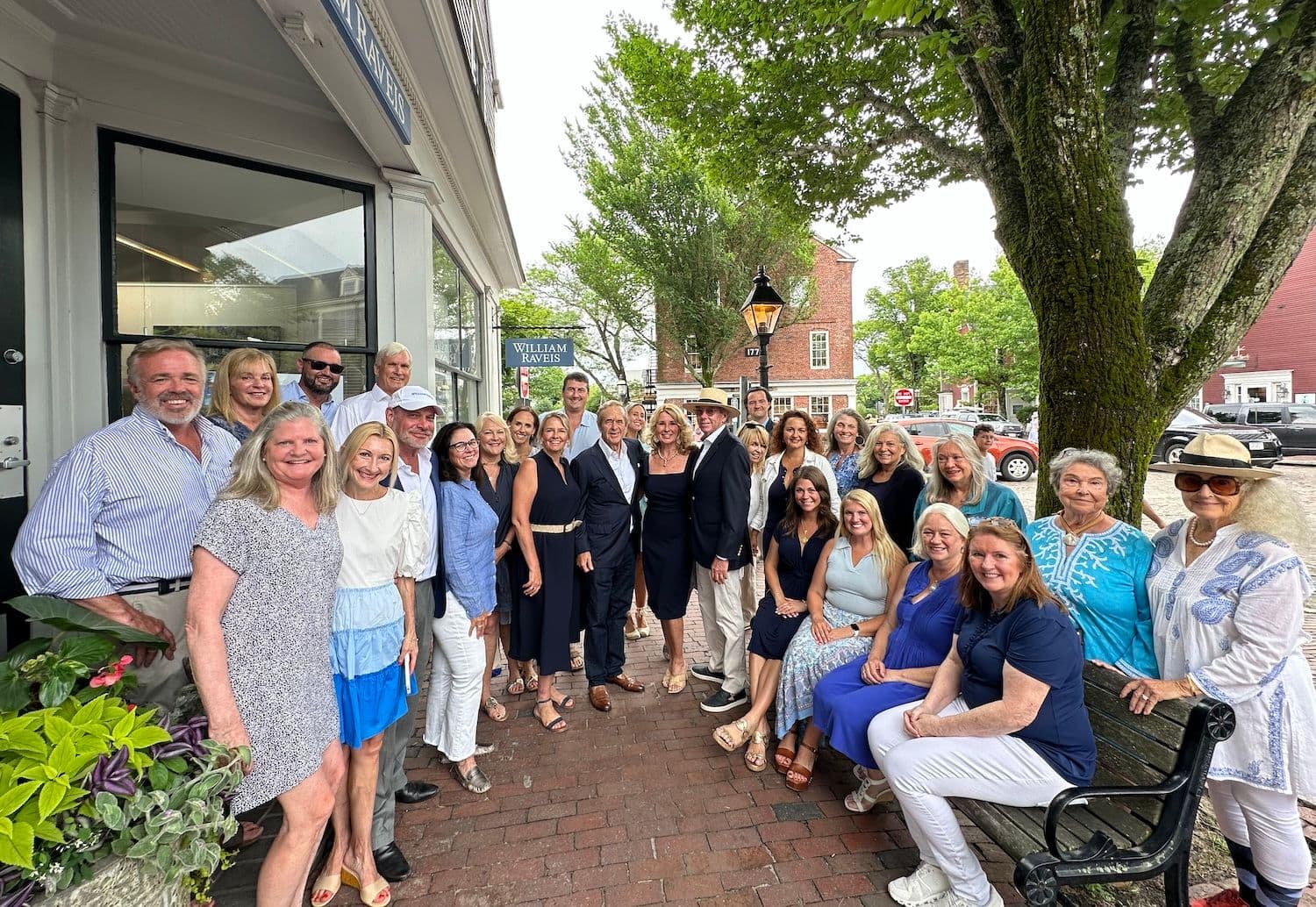 Group of people smiling and standing in front of store front on Nantucket Main Street.