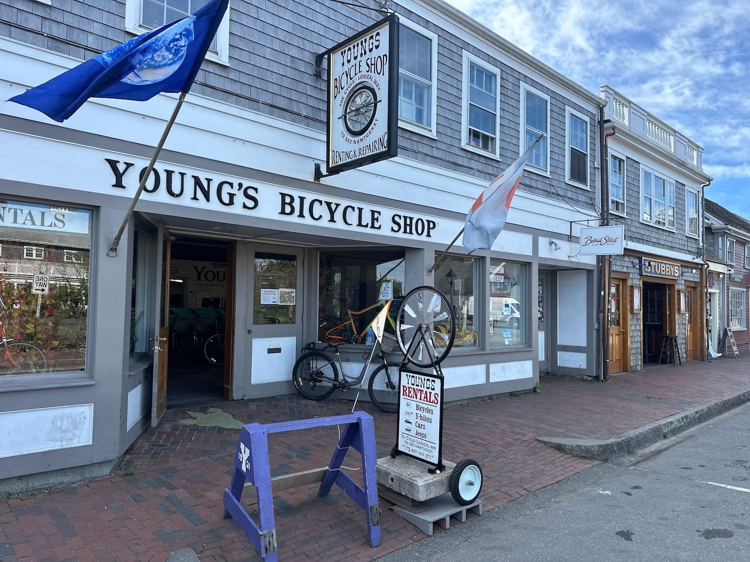 Flags and signs outside Young's Bicycle Shop.